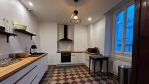 A compact kitchen with a checkered floor, a built-in oven, a coffee maker, and a hanging light fixture. - Mansion with swimming pool (Saint-Paul-lès-Dax)
