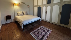 A bedroom with a bed, bedside table, wardrobe, and a rug. - Mansion with swimming pool (Saint-Paul-lès-Dax)
