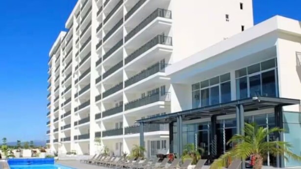 A hotel with a swimming pool, lounge chairs, and a modern building with balconies. - 508 New apartment, in Real Real View area 2 bedrooms (Zapopan)