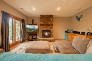 A living room with a fireplace, a television, and a sofa.