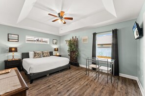 A bedroom with a bed, bedside tables, a desk, and a chair. - Beach House - Sunset by the Sea (Panama City Beach)