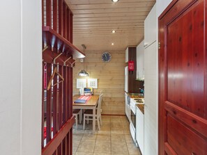 Uma cozinha pequena com armários de madeira, uma mesa de jantar e um relógio na parede.
