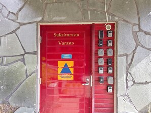 A red door with a sign reading 'Suksivarasto Varasto' and a blue and yellow triangle symbol. - Levin otava 2 by Interhome (Kittilä)