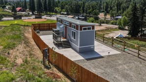 Une cabane moderne dotée d’une terrasse et offrant une vue sur un paysage montagneux.