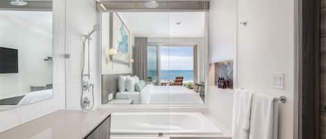 A modern bathroom with a large bathtub, a shower, and a mirror.