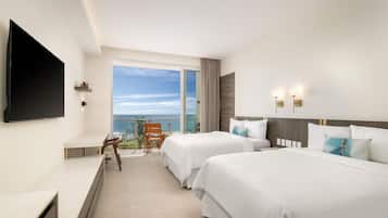 Une chambre d’hôtel avec deux lits, une télévision, un balcon avec vue et un bureau.