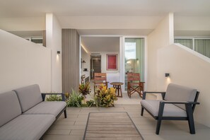Un intérieur moderne avec un canapé, des fauteuils, une petite table et une composition florale.