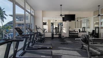 A gym with treadmills, weight machines, and dumbbells.