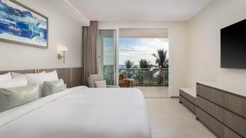 Een moderne hotelkamer met een groot bed, een flatscreen-tv, een balkon met uitzicht en een zithoek.