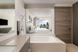 Une salle de bain moderne avec une baignoire, une douche et un grand miroir.