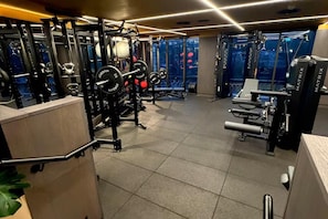Un gimnasio con diversos equipos de ejercicio, incluyendo máquinas de pesas y pesas libres.