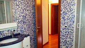 Une salle de bain avec un lavabo, un miroir et des murs carrelés.
