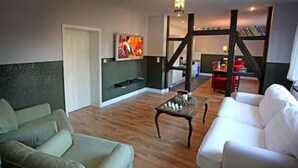 Een woonkamer met een bank, een salontafel en een televisie aan de muur.