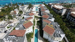 Ett semesterhotell med flera byggnader, en swimmingpool och utsikt över havet.