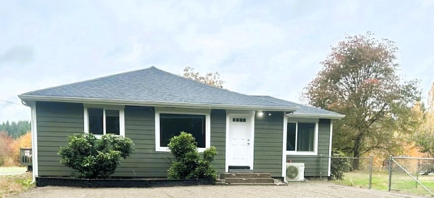 A single-story house with a gabled roof, a front porch, and a small front yard.