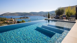 An infinity pool with clear blue water, overlooking a coastal town and the sea. - Breathtaking Villa Vis Five Bedroom Villa with the Pool (Vis)