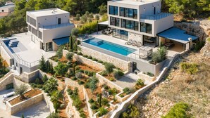 A modern two-story house with a swimming pool, stone retaining walls, and a lush garden. - Breathtaking Villa Vis Five Bedroom Villa with the Pool (Vis)