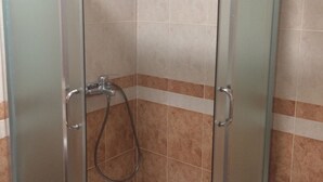 A shower enclosure with a glass door and a showerhead with a hose. - Apartments Aleksić, Bečići - Studio Apartment with Terrace 2 (Becici)