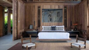 Ein geräumiges Schlafzimmer mit einem großen Bett, Holzwänden und einem Bild über dem Bett.