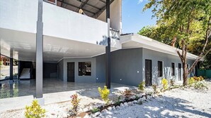 A modern two-story house with a covered patio area and a landscaped garden. - Downtown Apartment by The Beach #5 (Sámara)