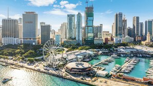 A waterfront cityscape with a prominent Ferris wheel, marina, and high-rise buildings. - The Vizcayne Vibe- Sauna, Pool and Sundeck (Miami)