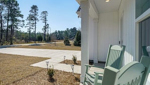 A porch with a white exterior, a clear sky, and a grassy area with trees in the background. - 4 Mi to Surf City Beaches! Family Coastal Retreat (Hampstead)