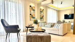 Ein modernes Wohnzimmer mit einer Couch, einem Sessel, einem Couchtisch und Kunstwerken an den Wänden.