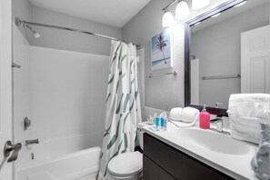 Een badkamer met een douche, toilet en wastafel.