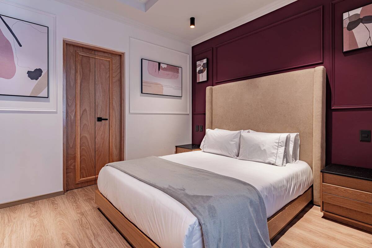 Ein Schlafzimmer mit einem großen Bett, einem Holzschrank und Bildern an den Wänden.