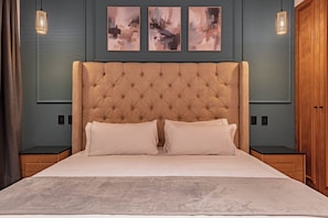 A bedroom with a tufted headboard, a large bed with two pillows, a grey rug, and three abstract paintings on the wall. - Frontera 23 by Escajal Homes (Mexico City)