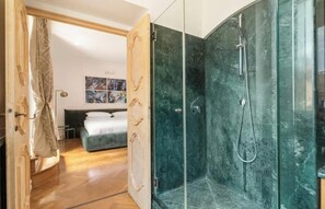 Une salle de bain moderne avec une douche à parois de verre et une porte en bois.