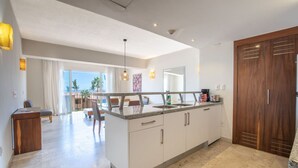 Een moderne keuken met een centraal eiland, een eetgedeelte met stoelen en uitzicht op de omgeving.