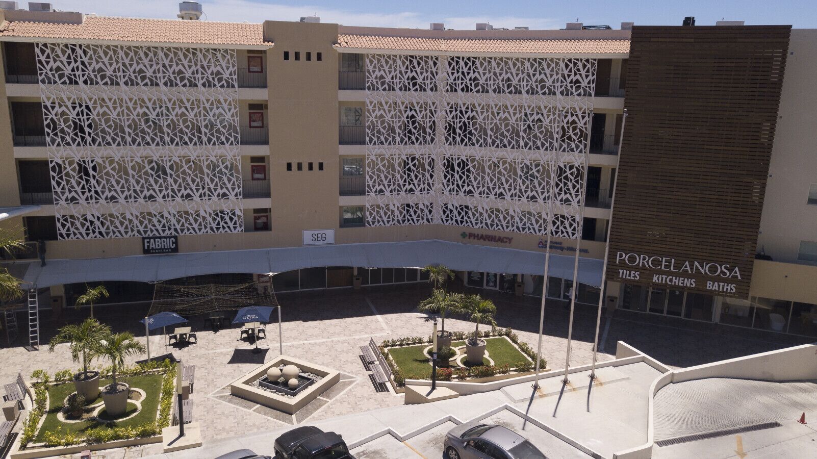 A building with a patterned facade, a pharmacy, and a tiles and kitchens store.