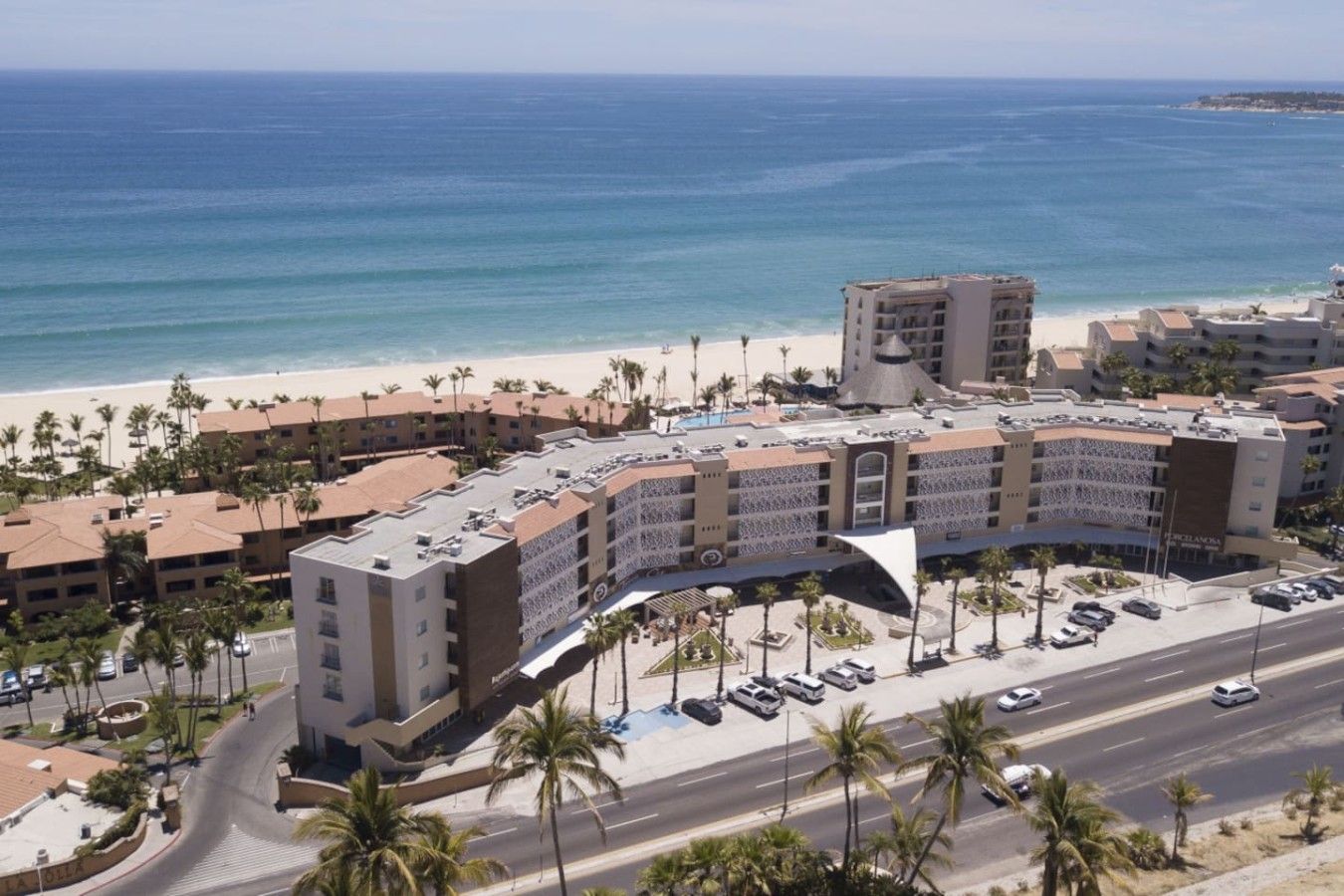 Un hôtel à étages, doté d’une cour intérieure et offrant une vue sur la plage.