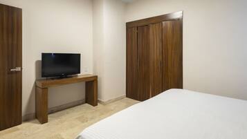 A hotel room with a bed, a TV on a wooden stand, and a wardrobe.