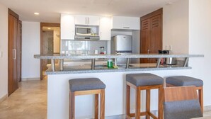 A modern kitchen with granite countertops, stainless steel appliances, and wooden cabinets. - Depto a 5 min del mar y el centro de El Cabo 304 (San José del Cabo)
