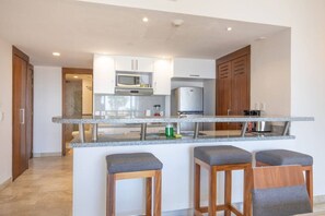 Eine moderne Küche mit Granit Arbeitsplatten, Edelstahlgeräten und Holzschränken.