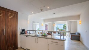 A modern kitchen with a central island, a dining area with a view, and a separate seating area. - Depto a 5 min del mar y el centro de El Cabo 304 (San José del Cabo)