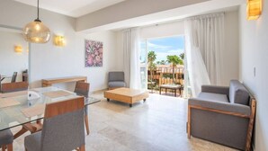 A modern living room with a glass dining table, grey sofas, a wooden coffee table, and a balcony with a view of palm trees. - Depto a 5 min del mar y el centro de El Cabo 304 (San José del Cabo)