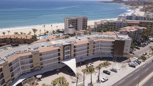 Un hôtel doté d’une piscine, offrant une vue sur la plage et disposant d’un parking.