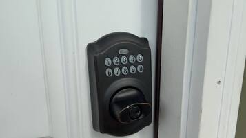 A door with a keypad lock and a round doorknob, labeled "Back Entry".