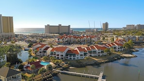 Um hotel à beira-mar com vários edifícios, uma marina e vista para o oceano.