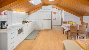 Eine moderne Küche mit weißen Schränken, einer Kaffeemaschine und einer Obstschale auf der Arbeitsfläche.