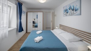 A hotel room with a bed, a wardrobe, a desk, and a painting on the wall. - Amazing apartment in Zambratija with WiFi (Zambratija)
