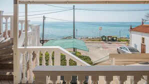 A balcony with a view of the sea, a parked car, and a trash bin. - Amazing apartment in Zambratija with WiFi (Zambratija)