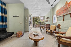 A living room with a sofa, a round wooden table, and two wooden chairs. - Romantic Zone by Monyxbnb (Puerto Vallarta)