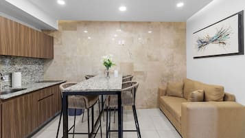 Departamento Deluxe, 1 cama matrimonial y sofá cama, para no fumadores, vista a la ciudad | Área de sala de estar | Televisión LED de 50 pulgadas con canales digitales