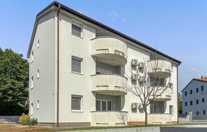 Een meerlaags gebouw met balkons, airconditioners en een zichtbaar raam.