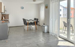 A modern kitchen with a dining area, a small trash bin, and a view of the outside. - 2 bedroom nice apartment in Cizici (Cizici)