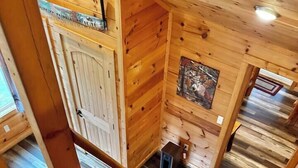 Ein Holzinnenraum mit Treppe, einer Tür und einem kleinen Tisch.